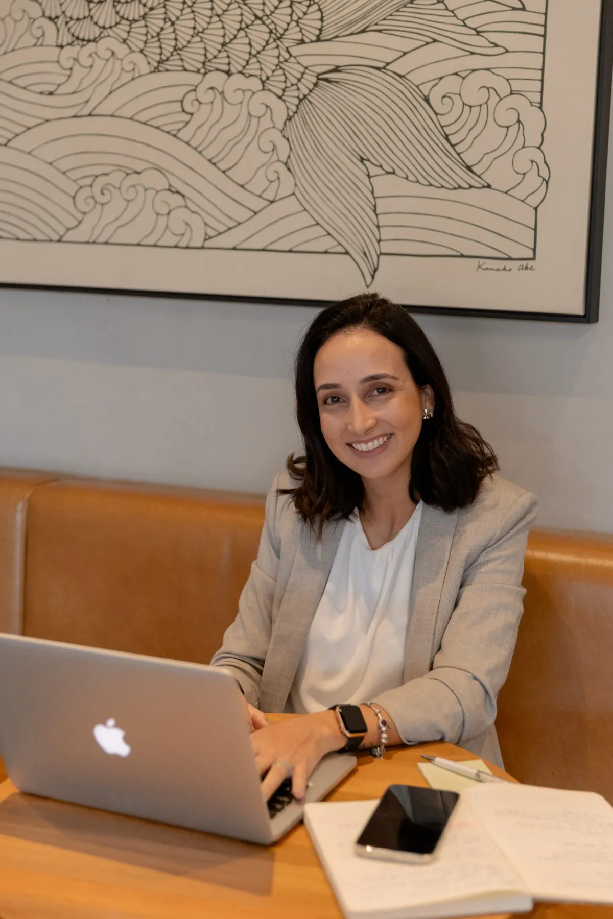 Laís Sass, fundadora da Up!, trabalhando com notebook e planner em um café